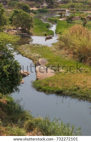 fluent river with rocks, vegetation, fisherman and boat in africa. Lubango. Angola.