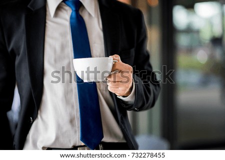 Portrait of handsome business man drinking coffee in cafe
