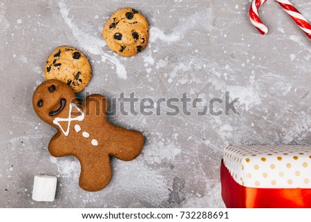 Gingerbread, cookies, marshmallows, red white cnadies lie on the floor around present box
