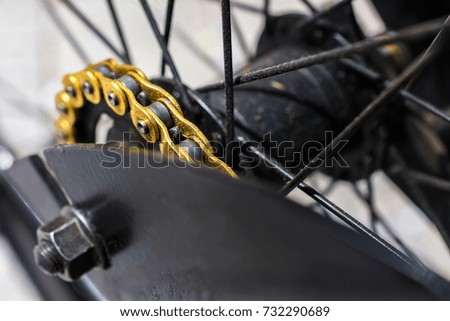 macro detail of golden chain of a black bike