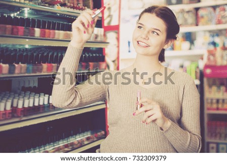 Adult customer searching for reliable lipstick in cosmetics shop