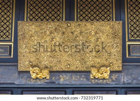 Old blank wooden board over door with lion's Chinese tradition art. Golden colour painted. Board over main entrance of Chinese temple style. Space for text.