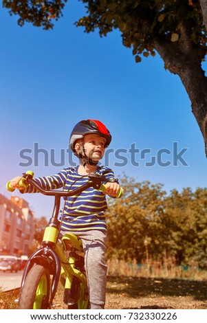 Happy boy ride a bicycle in city park