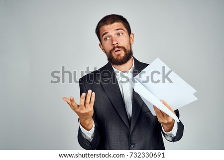 business man in suit looking sideways in hand documents on light background                               