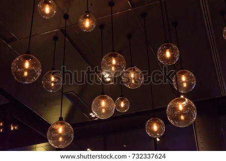 Retro luxury light lamp decor glowing.hanging incandescent lamp with glowing light bulb in dark room as decoration idea for interior and holiday and abstract background in hipster style.