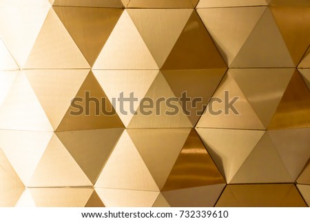 golden geometric wall made from aluminum sheet. Gold Polygonal  Background.