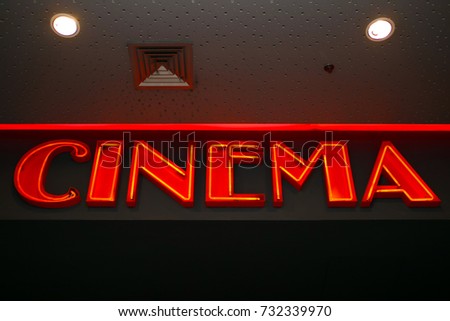 The word cinema is written on a wall with red neon.