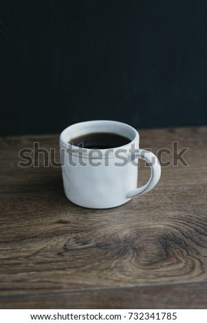 White mug with coffee on dark background. homemade coffee cup 