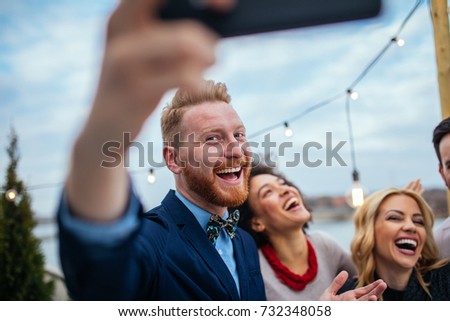 Friends taking a photo with mobile phone.