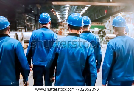 Abstract, blurry, bokeh background, image for the background. People in overalls in production Royalty-Free Stock Photo #732352393