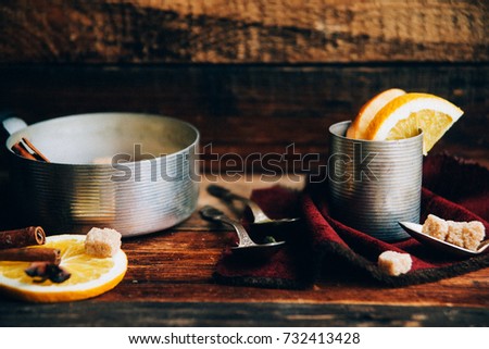hot drink, mulled wine red, ingredients for mulled wine: orange, Apple, cinnamon, cloves, ginger in a bowl on wooden background Retro toned photo. Copy space for your text.