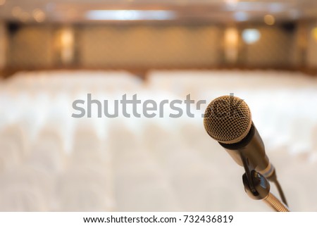 Microphone with blurred photo of conference hall seminar room event background.
(selective focus )