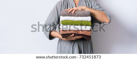 female hand holding stack clean bath towels colorful cotton terry textile background closeup Royalty-Free Stock Photo #732451873