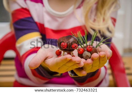 lovely child with autumn decoration made from chestnut fruit