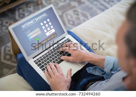 Internet banking text on blue display against man using laptop in living room