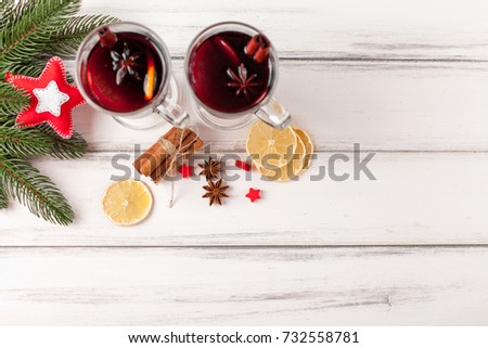 Mulled wine banner with glasses of hot red wine and spices on white wooden background. Closeup photography of warm winter alcohol drink.