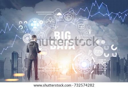 Rear view of a young bearded businessman wearing a suit and a white shirt and holding a document. A big data hologram in a city. Toned image double exposure 