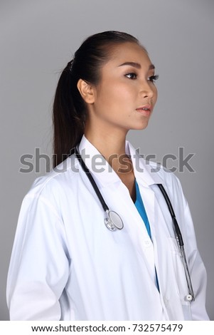 Asian Woman after applying make up black hair style. no retouch, fresh face with acne, mole, nice and smooth skin. Studio lighting grey background, concept doctor look with stethoscope