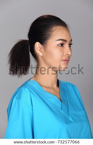 Asian Woman after applying make up black hair style blue shirt. no retouch, fresh face with acne, nice and smooth skin. Studio lighting grey background