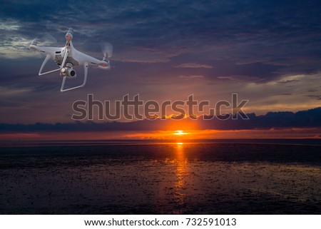 UAV drone copter flying with digital camera.Drone with high resolution digital camera. Flying camera take a photo and video.The drone with professional camera takes pictures of the Sunset / Sun rise.