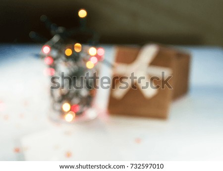 Christmas garland with lights and a gift box with a blank postcard on a light background. Christmas gift. Very blurry and toning
