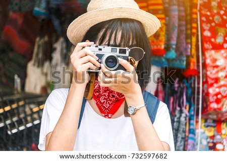 Asian woman taking picture with camera
