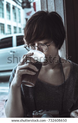 Short hair woman is photographer drink the coffee on the morning.The picture is vintage style.