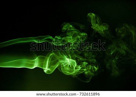 Green smoke on black background.