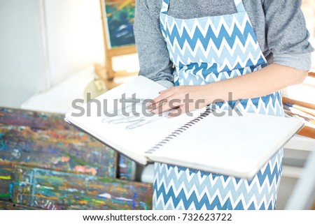 Pretty blode girl looking on a album and smiling. Art concept,