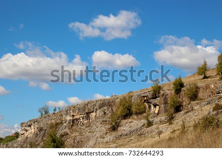 Landscape with beautiful fluffy clouds over autumn field