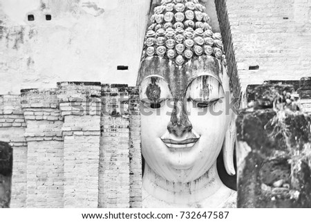 The image of Ancient face of Buddhist statues in Thailand, which was built in the late 14th century, there is a huge 11 meters wide and 15 meters high. Black and white picture.
