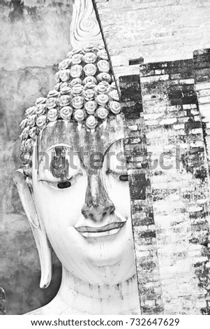 The image of Ancient face of Buddhist statues in Thailand, which was built in the late 14th century, there is a huge 11 meters wide and 15 meters high. Black and white picture.