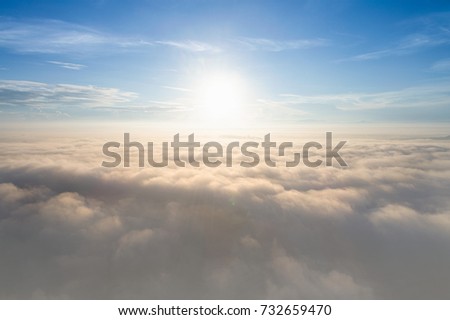 Aerial view from drone flying above the clouds , Morning time with sun flare light ray