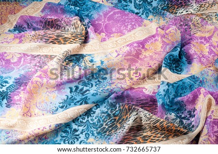 Texture background image, silk fabric, with abstract pattern. Blue, white, yellow, red. The folds of the fabric are convenient for the background, screensaver, wallpaper on the desktop.