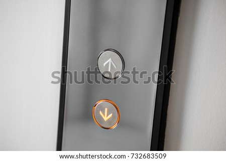 Close up elevator button over white wall.
