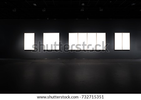 black wall with picture frames in long corridor