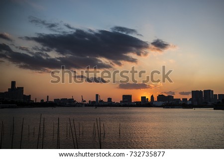 View of a beautiful sunset behind the Tokyo skyline. Photo taken from the island of Odaiba, in Japan.