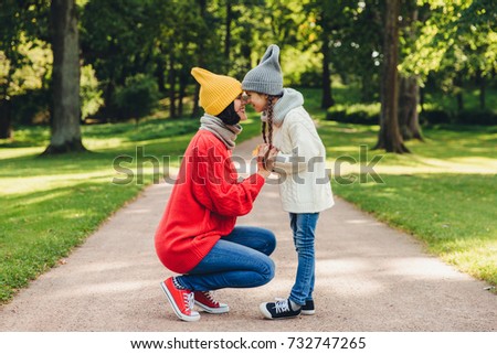Portrait of mother and daughter keep noses closely to each other, enjoy calm atmosphere, have understanding between each other. Adorable child loves her mom greatly. Closeness concept