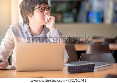 Young Asian business man feeling stressed, tired and headache during working with laptop computer in public co working space. freelance lifestyle in workspace.