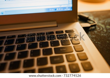 Close-up of laptop keyboard with focus on Backspace button and highlighted with warm evening light