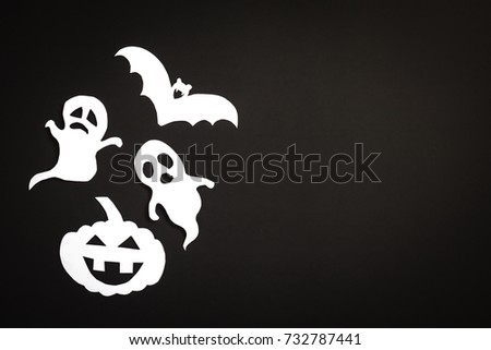 Halloween holiday background with pumpkin, ghosts and bat cut paper on black background. Free space for text.