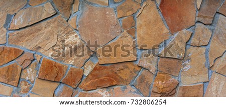 Rough orange pieces concreted granite stone wall background