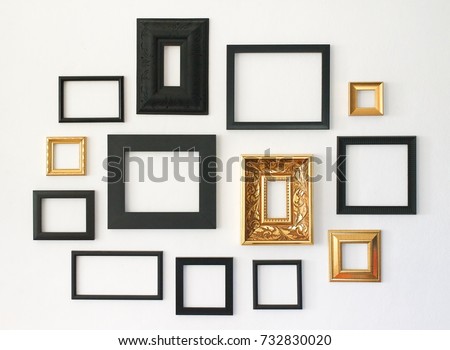Multiple many blank small picture frames on white wall Royalty-Free Stock Photo #732830020