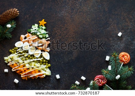 Christmas tree from a salad olivier on a brown rusty stone or metal background.  Beautiful Christmas and New Year background for food top view of a blank space for text. Royalty-Free Stock Photo #732870187