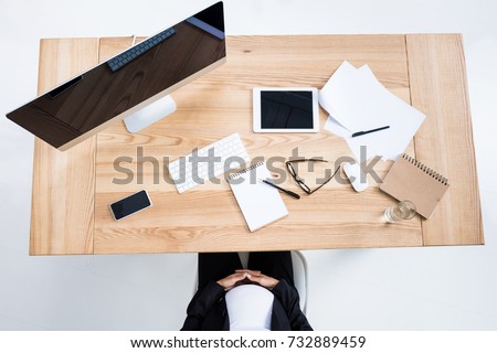 top view of pregnant businesswoman sitting at workplace in modern office