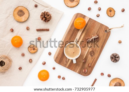 Cup of coffee, pine cone, tangerine, christmas decoration, nuts, wood slice on white background, flat lay, top view