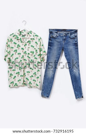 Green Palm Tree Textile Pattern painted clothes hanging with blue jeans isolated 