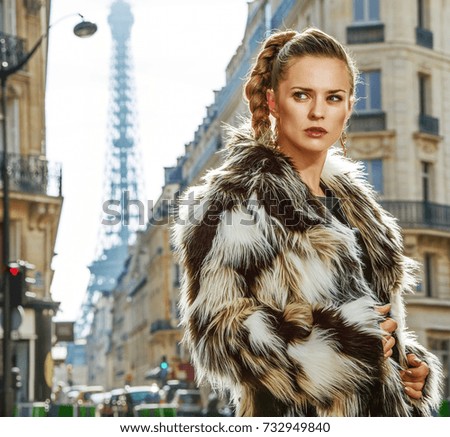 Boiling hot trendy winter in Paris. Portrait of modern fashion-monger in fur coat in Paris, France looking aside