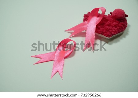 Health care and Medicine Concept - A pink ribbon and a pink heart shape over a white background. Breast cancer awareness pink sign symbol for help illness people