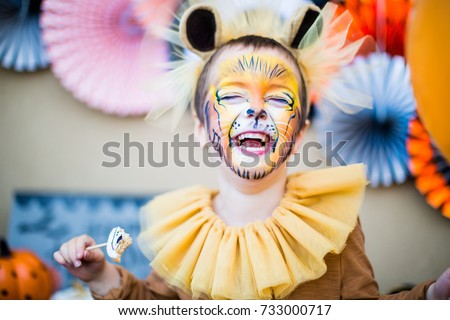 Boy in lion fancy dress laughing at children's halloween party Royalty-Free Stock Photo #733000717
